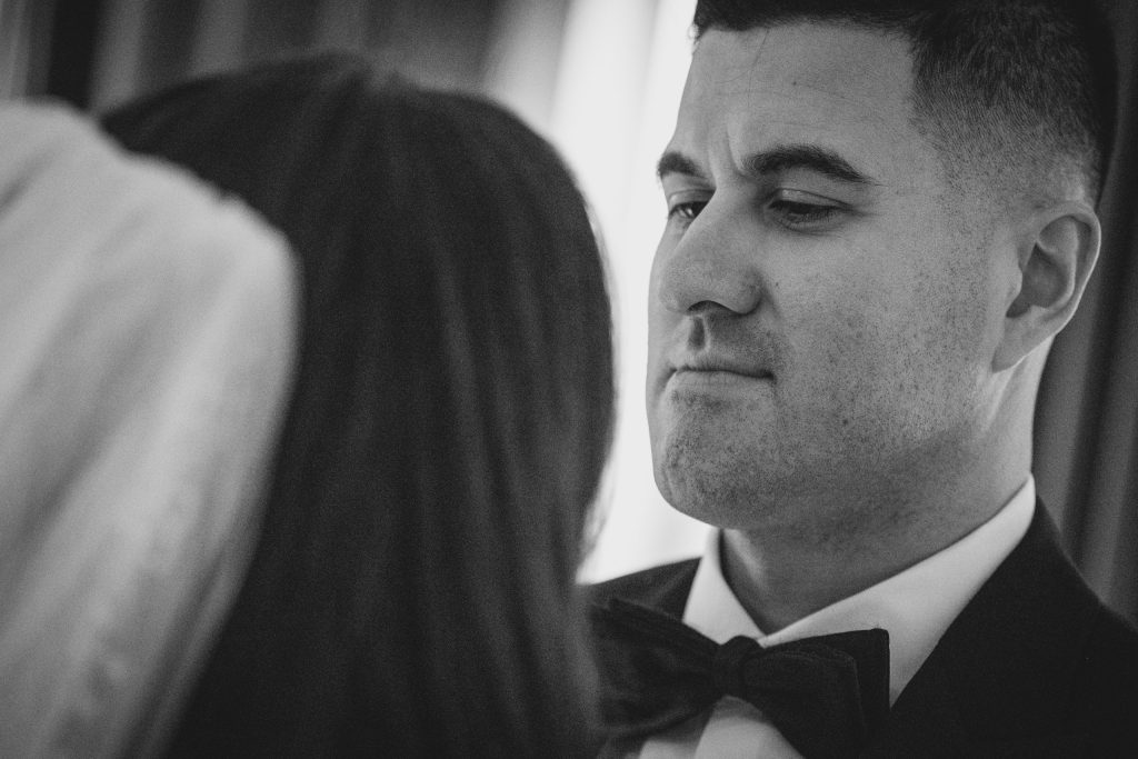 Intimate black and white close-up portrait of the groom gazing at the bride