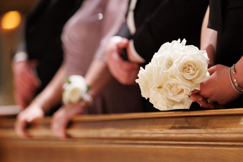 Close-up of the bride's white rose bouquet held during the wedding ceremony